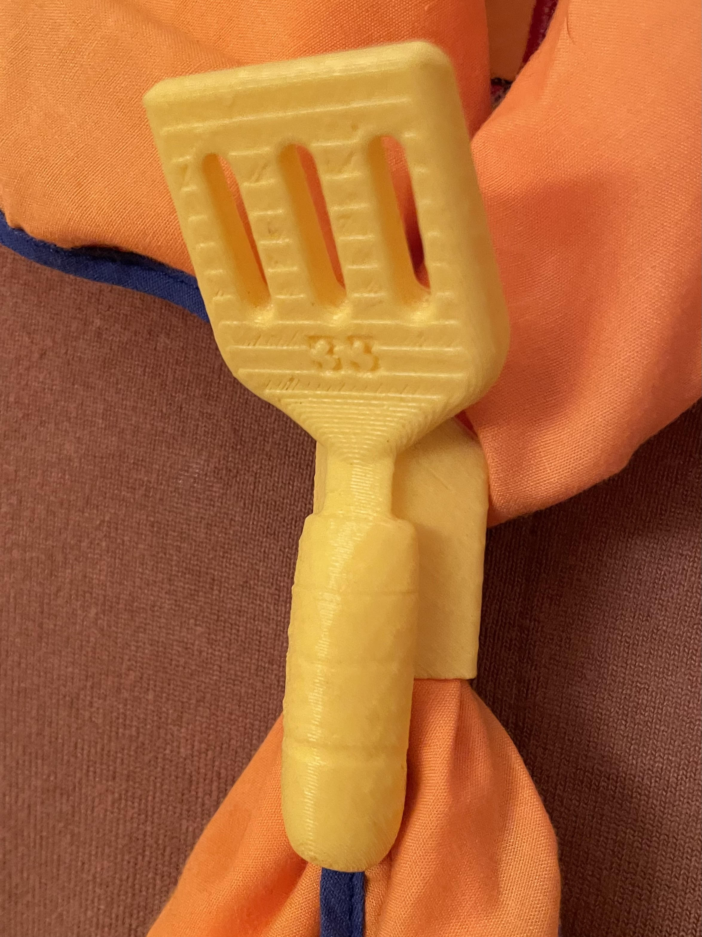 A bright blue and gold custom neckerchief slide worn on a Scout uniform.